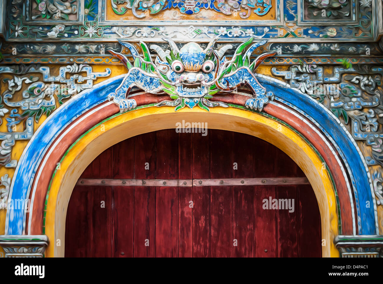 Gran portón en madera oscura y una decoración colorida con símbolo tradicional, la ciudad Hue en Vietnam. Arco Imperial entrada decorada con Foto de stock
