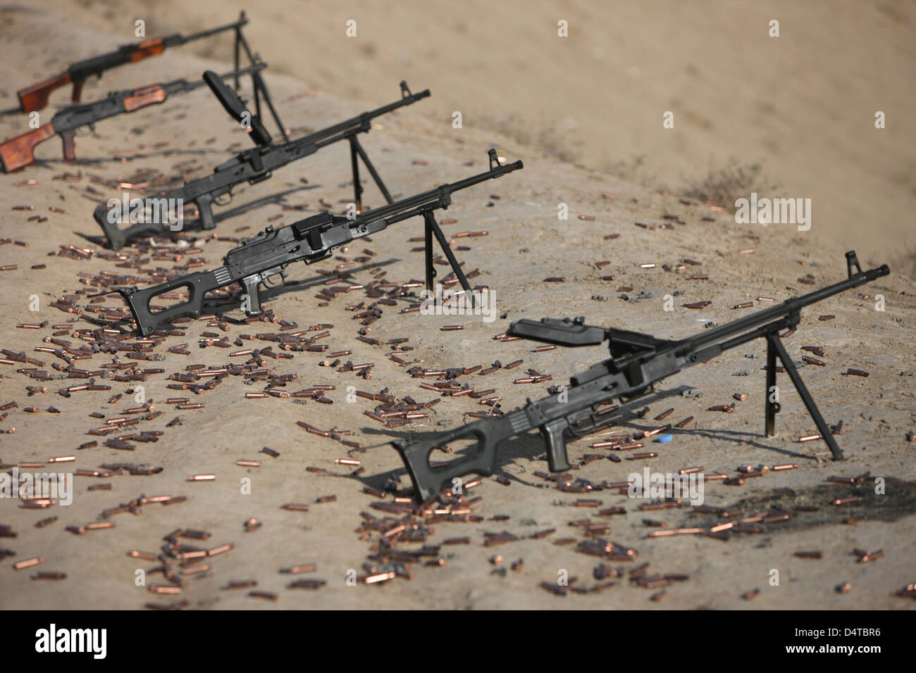PK ametralladoras y cartuchos usados en el campo de tiro. Foto de stock