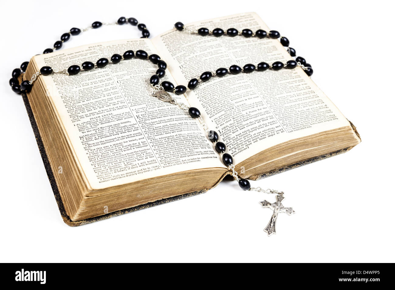 Rosario y cruz acostado sobre una página abierta de la biblia aislado sobre  un fondo blanco Fotografía de stock - Alamy