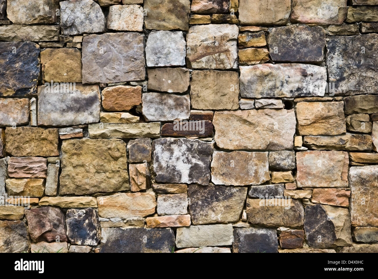 Una pared de roca natural bellamente diseñado. Muchos colores y tamaños mezclados por intereses. Foto de stock