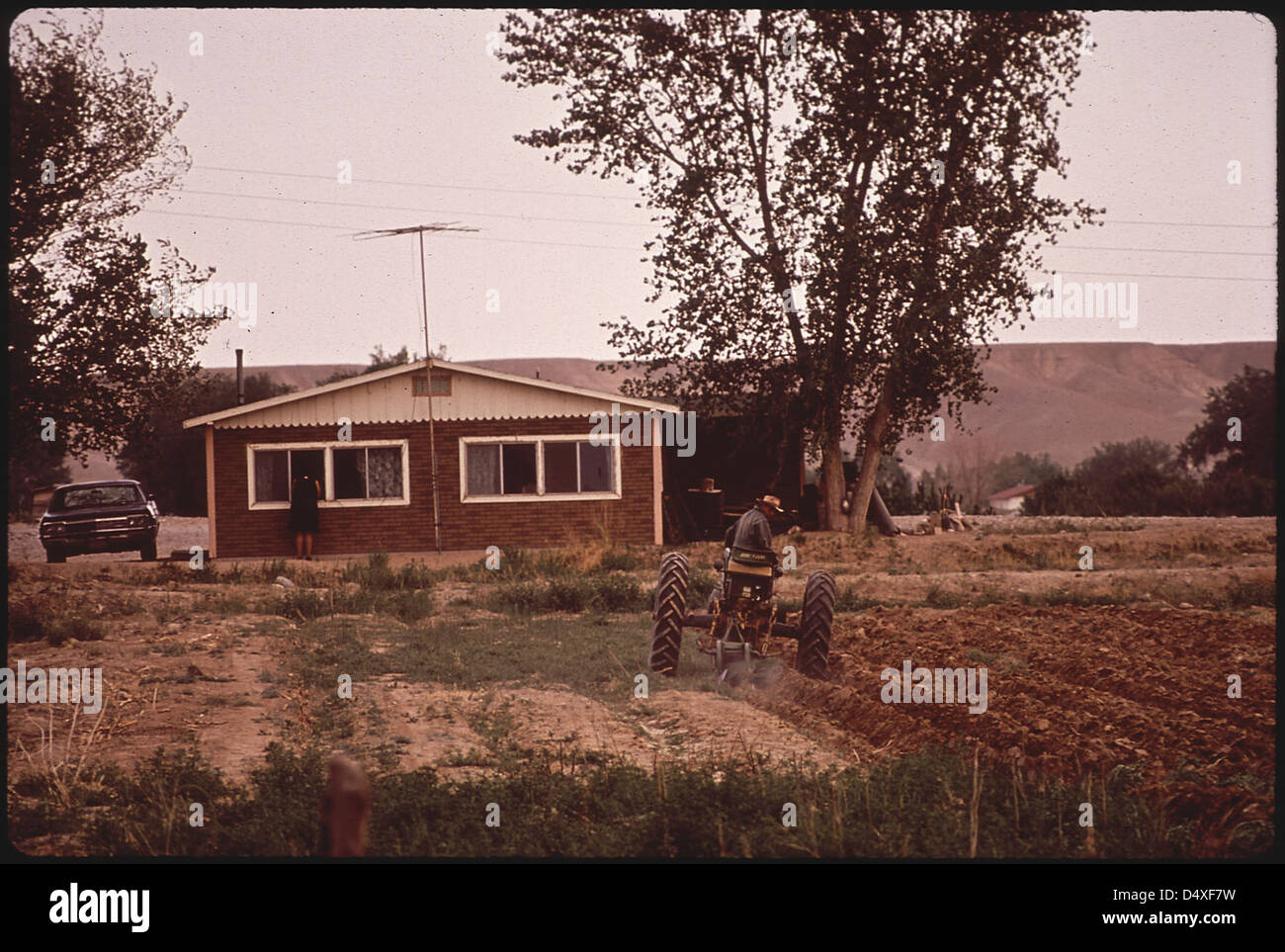 Navajo arar su jardín. Como cualquier Middle-Class Suburbanite, su casa tiene una antena de TV en la parte superior y un coche aparcado junto a Foto de stock