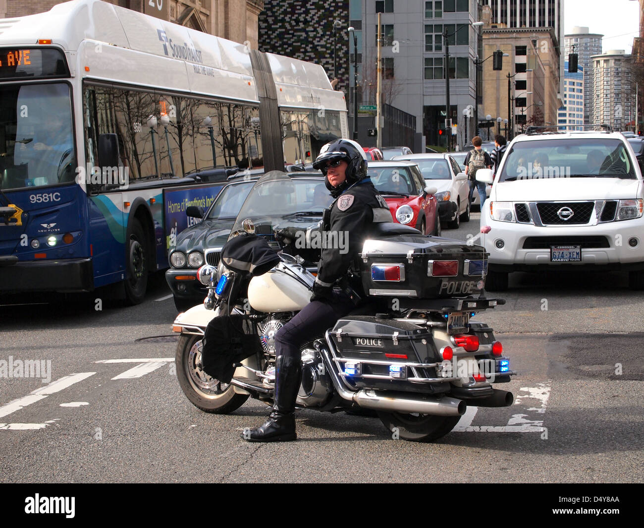 El Departamento de Policía de Seattle motocicleta cop detiene el tráfico en una manifestación contra la policía en el centro de la ciudad de Seattle, Washington, EE.UU. Foto de stock