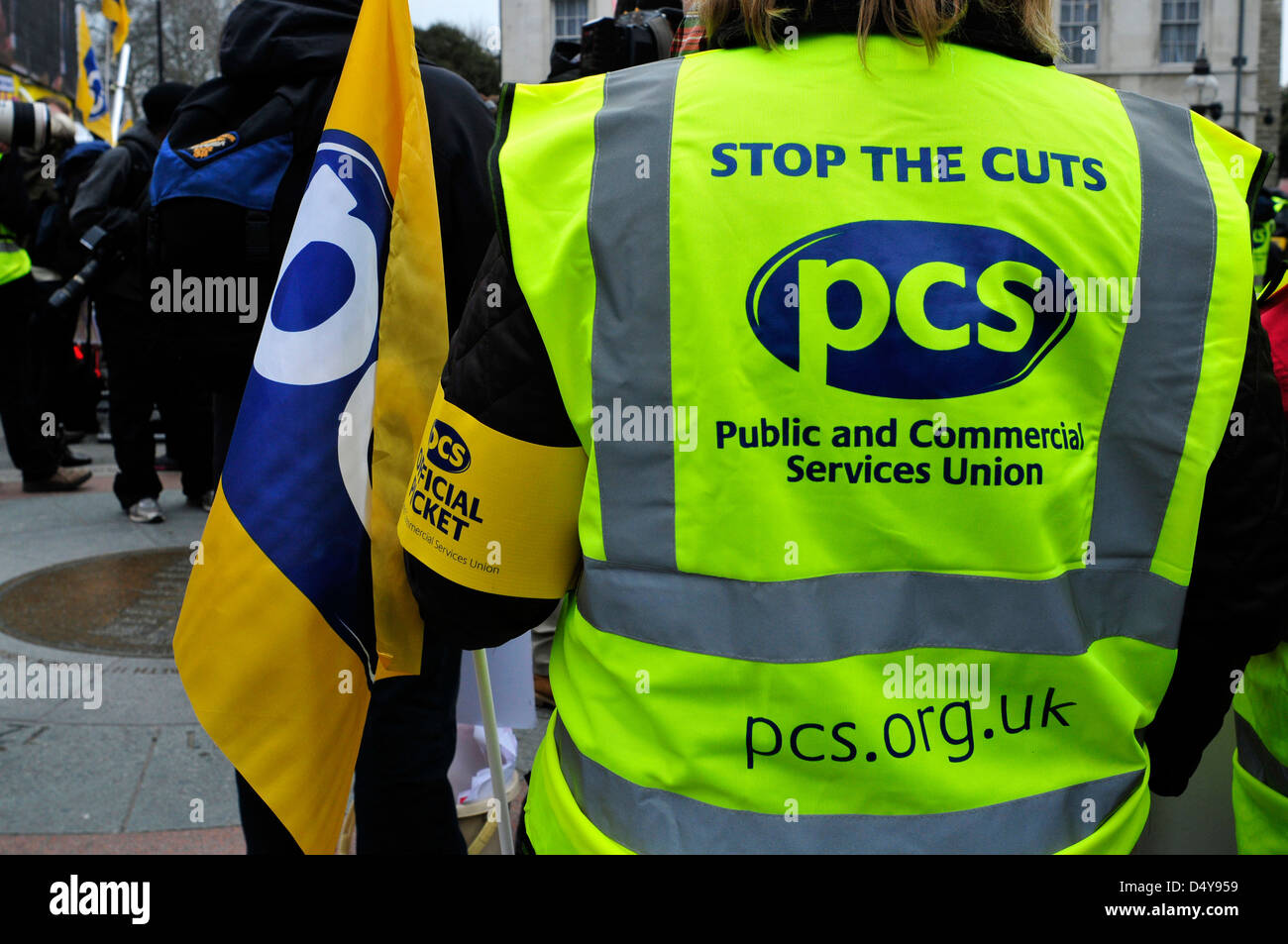 Un huelguistas vistiendo un chaleco reflectante con lemas ' Detener los recortes", en una manifestación fuera del parlamento sobre el presupuesto del día. Londres. Foto de stock
