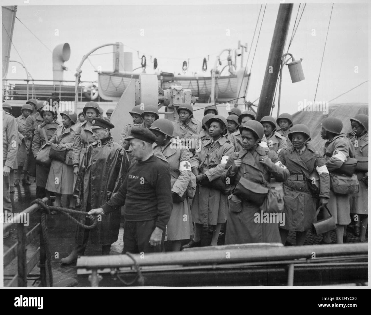 Las enfermeras del ejército de los Estados Unidos, recién llegados, alinean el ferrocarril de su embarcación mientras se desplaza hacia el puerto de Greenock, Escocia, en el Teatro Europeo de Operaciones. Foto de stock