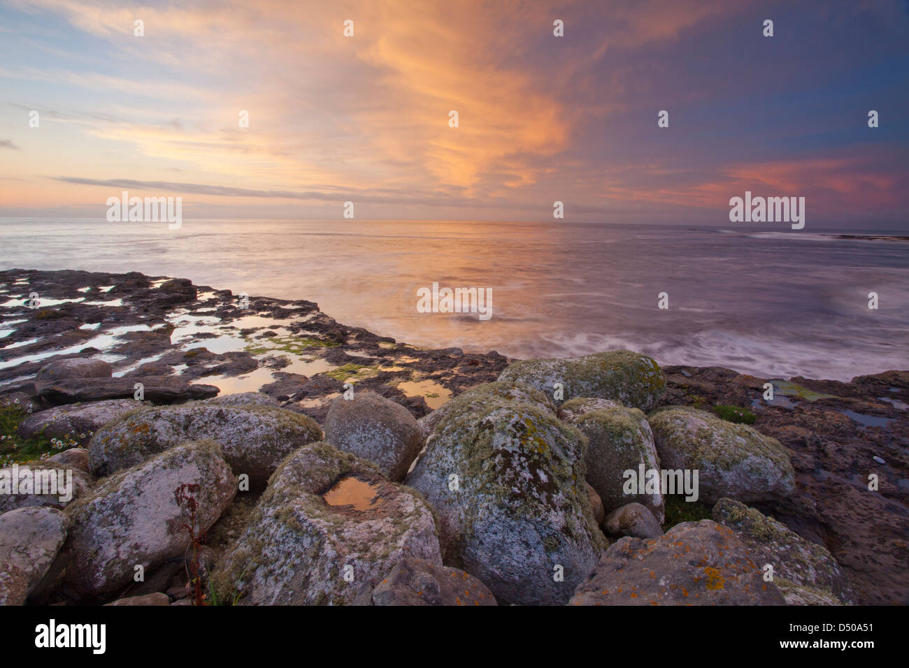 Puesta de sol sobre los cantos rodados costeros en Easky, condado de Sligo, Irlanda. Foto de stock