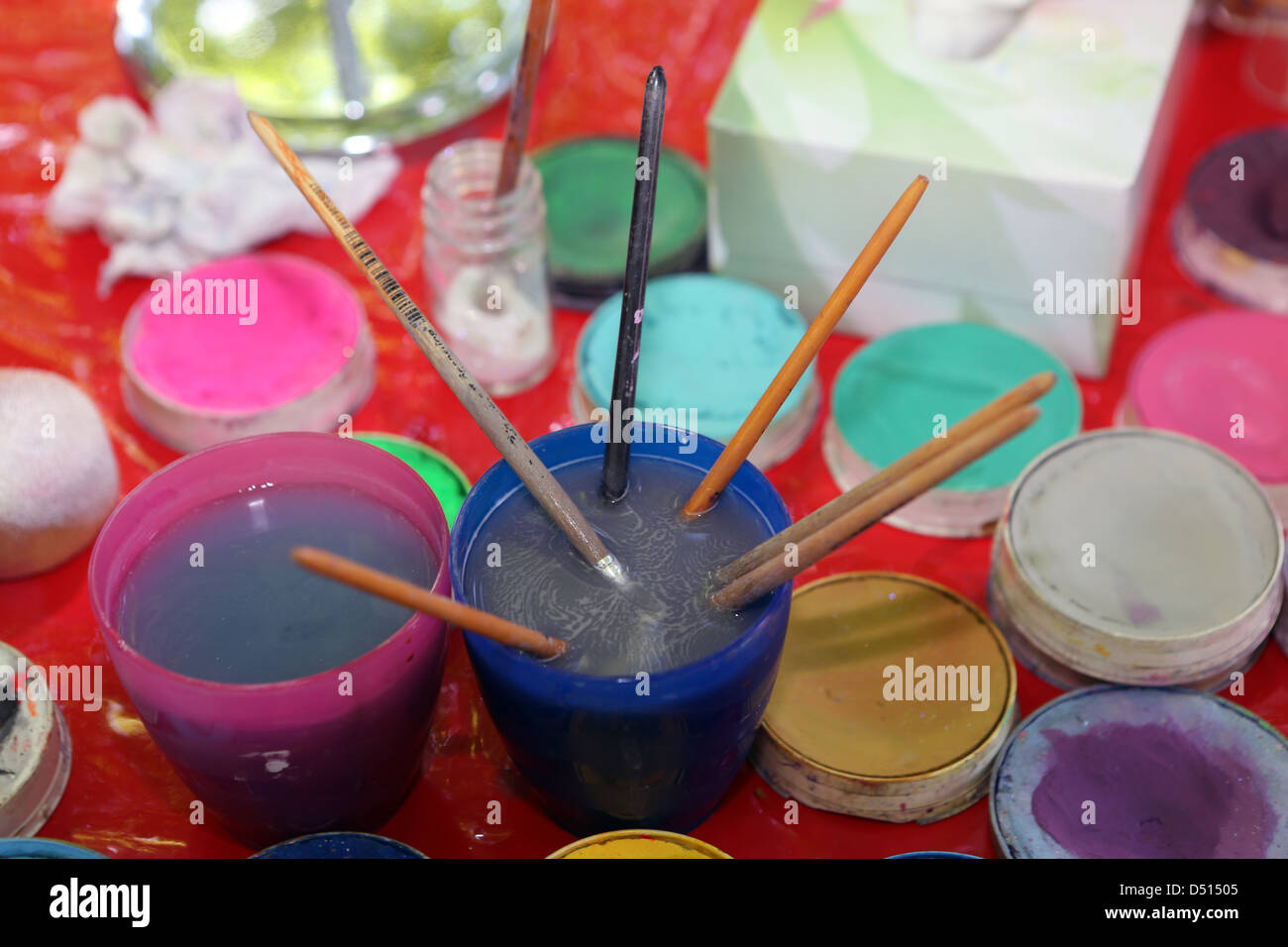 Hannover, Alemania, colores de tinta y pinceles usados en una taza de agua Foto de stock