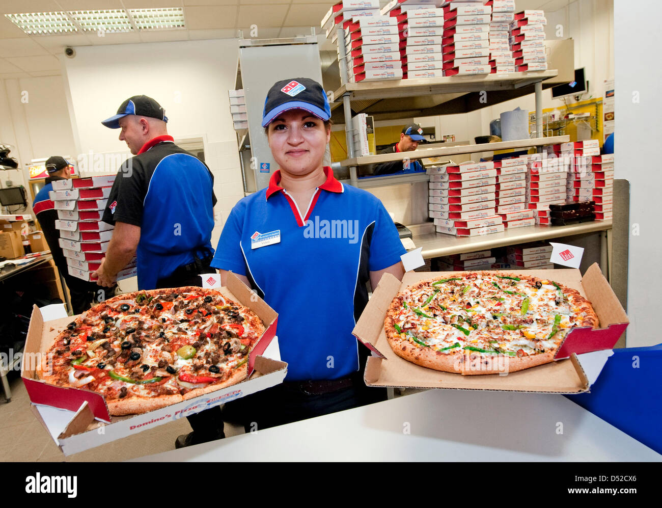 Un miembro del personal de US cadena de pizzerías Domino's Pizza manos una  pizza a un cliente en la cadena de la primera tienda de la cadena alemana  en Berlín, Alemania, 04