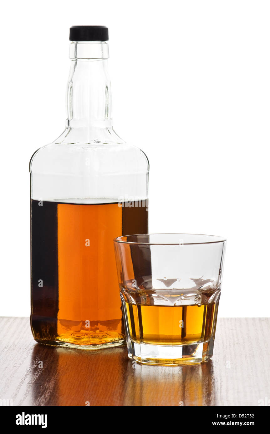 Vidrio y botella de whisky sobre un fondo blanco. Foto de stock