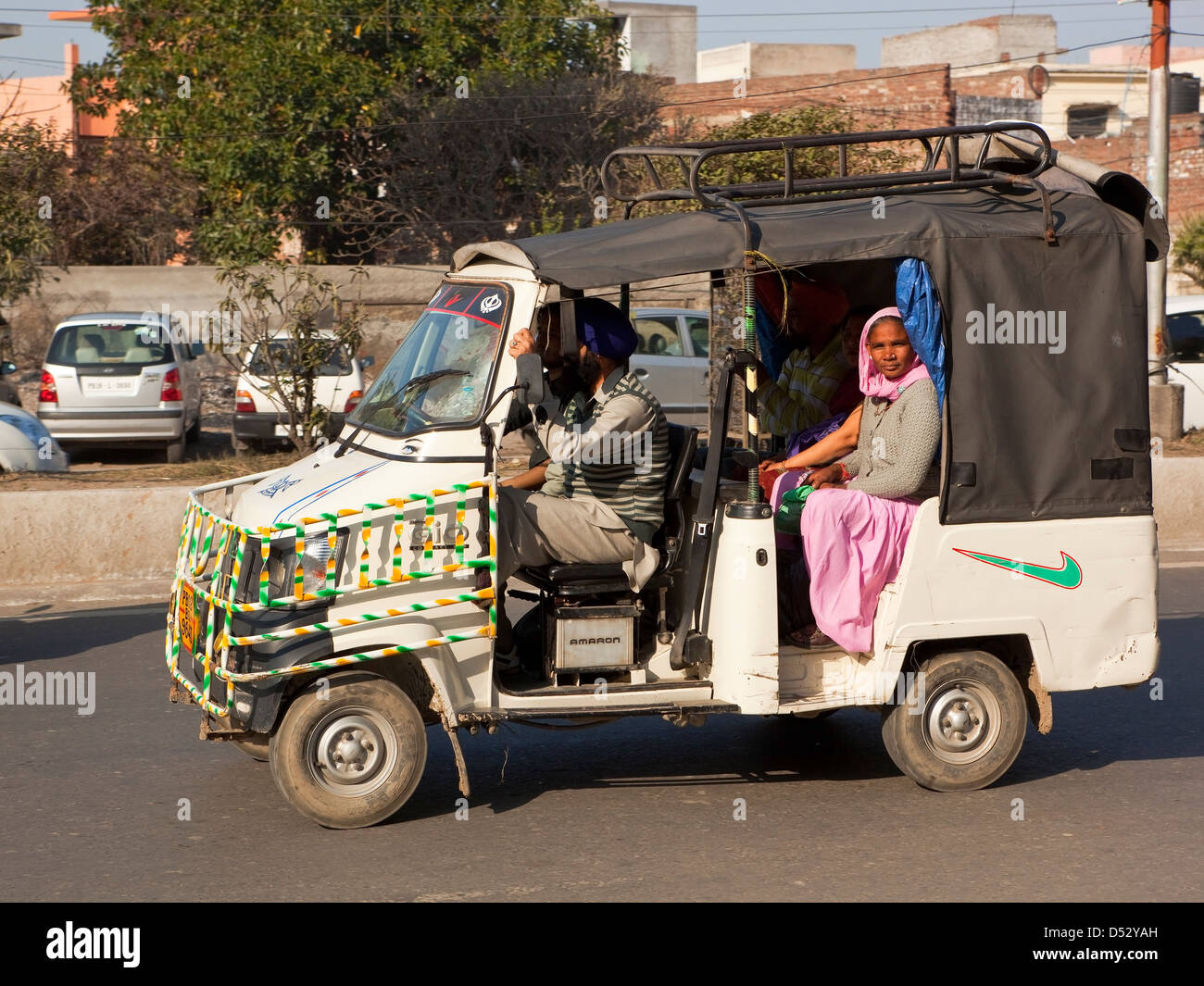 Un pequeño taxi lleno de pasajeros en las calles de Amritsar, Punjab, India Foto de stock