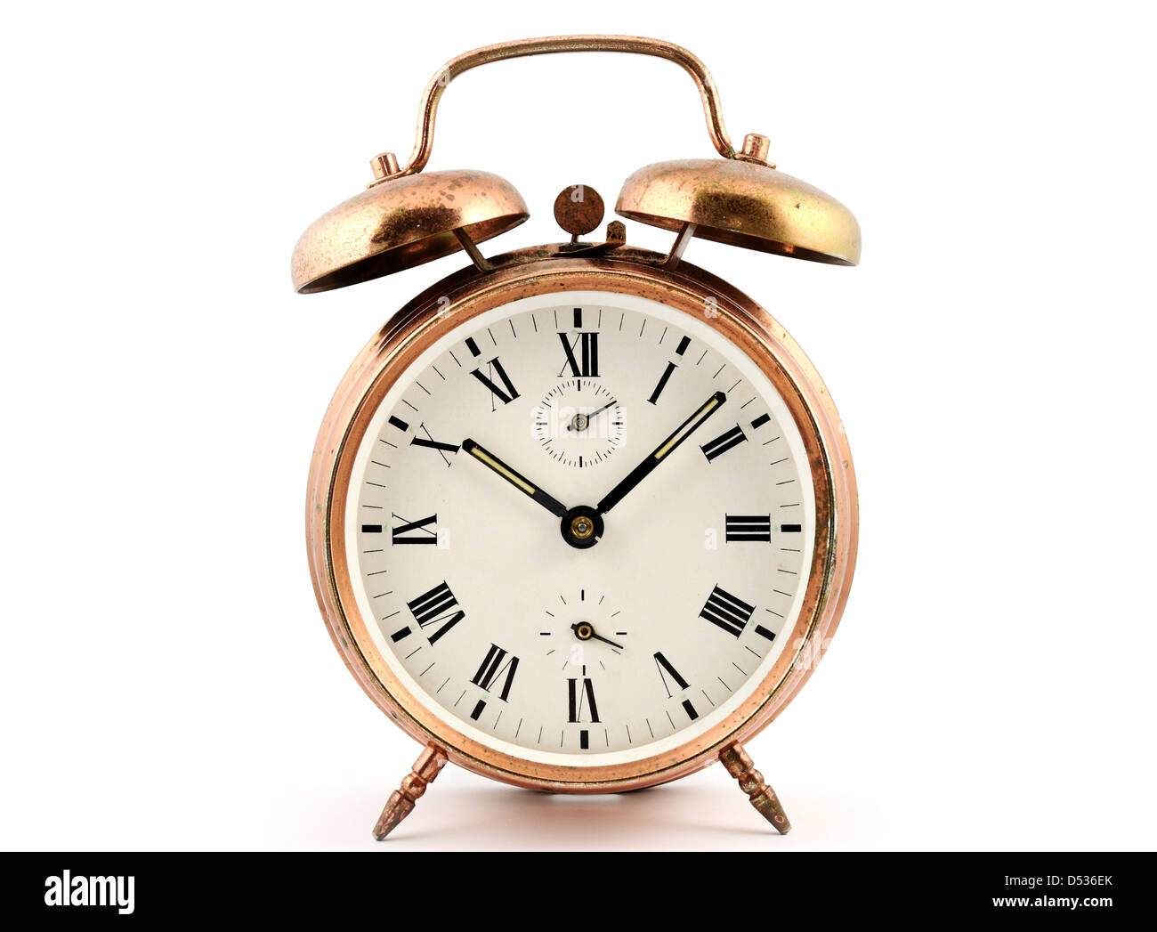 A la vieja usanza de cobre vintage reloj alarma contra un blanco Foto de stock