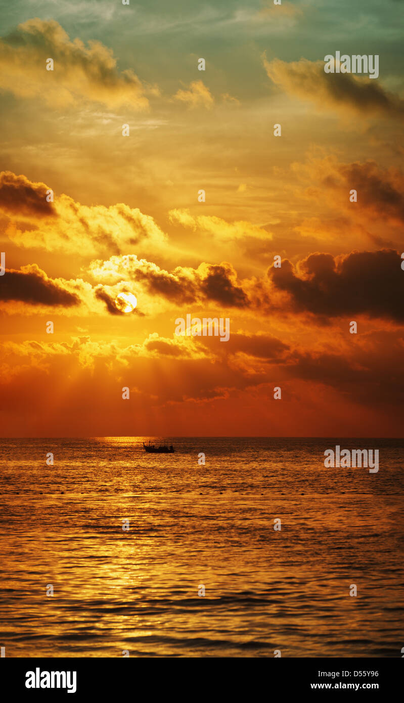 Puesta de sol sobre el océano, con barco. Panorámica de alta resolución vertical. Foto de stock