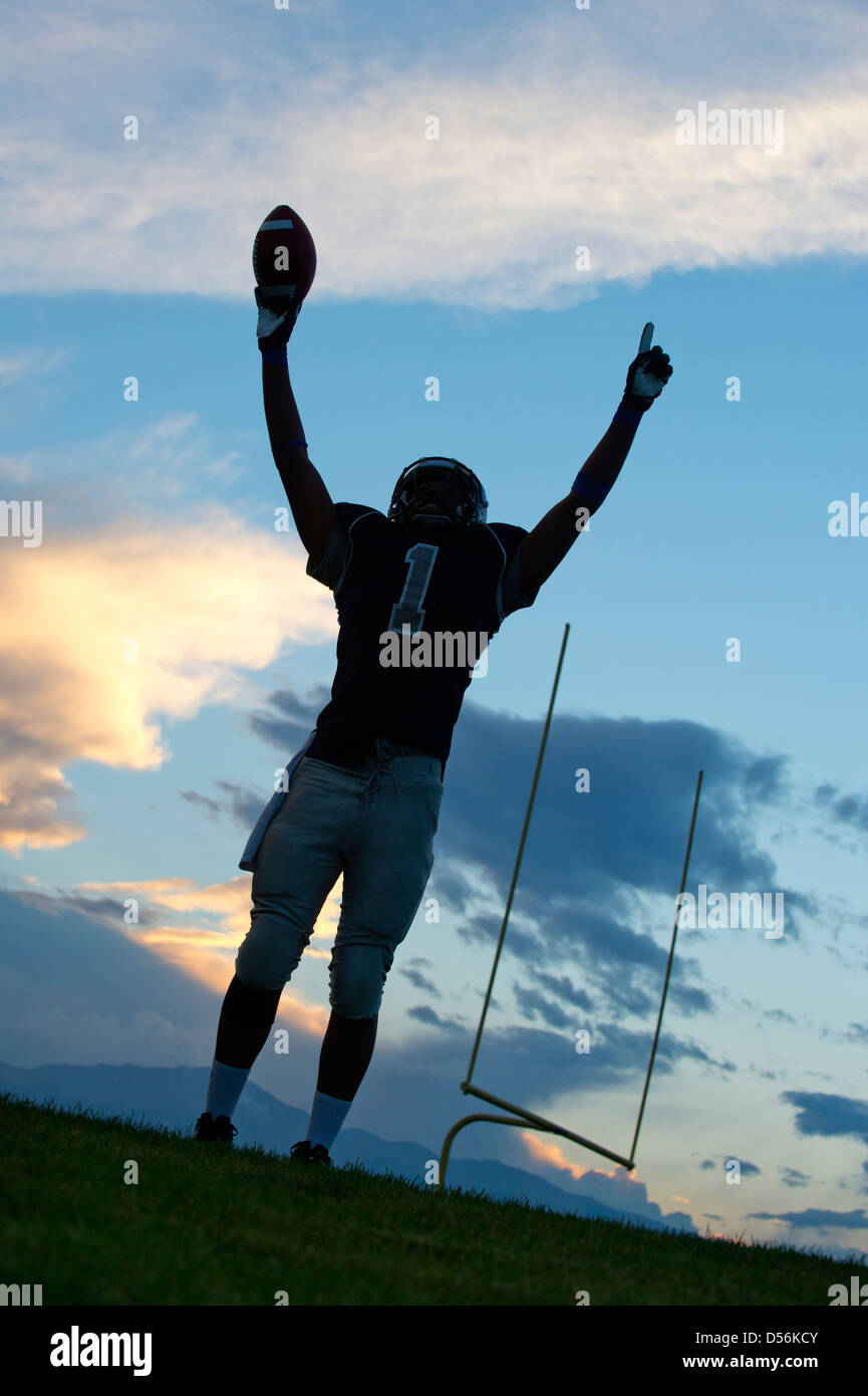 Jugador de fútbol americano africano aclamando en el juego Foto de stock