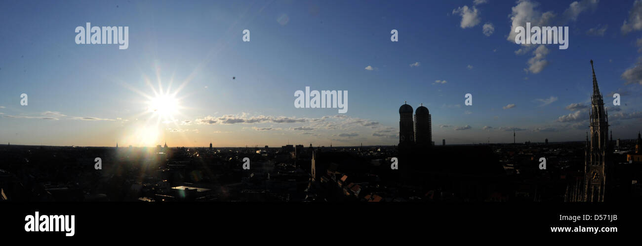 Un cielo azul con muy pocas nubes blancas poco vistos por encima del Ayuntamiento de Munich (R) y la iglesia de Nuestra Señora (C) en la capital de Baviera, Alemania, 02 de abril de 2010. Temperaturas primaverales invitó a muchos ciudadanos durante un paseo de Viernes Santo. Baviera el blanco y el azul son los colores "nacionales". Foto: Felix Hoerhager Foto de stock