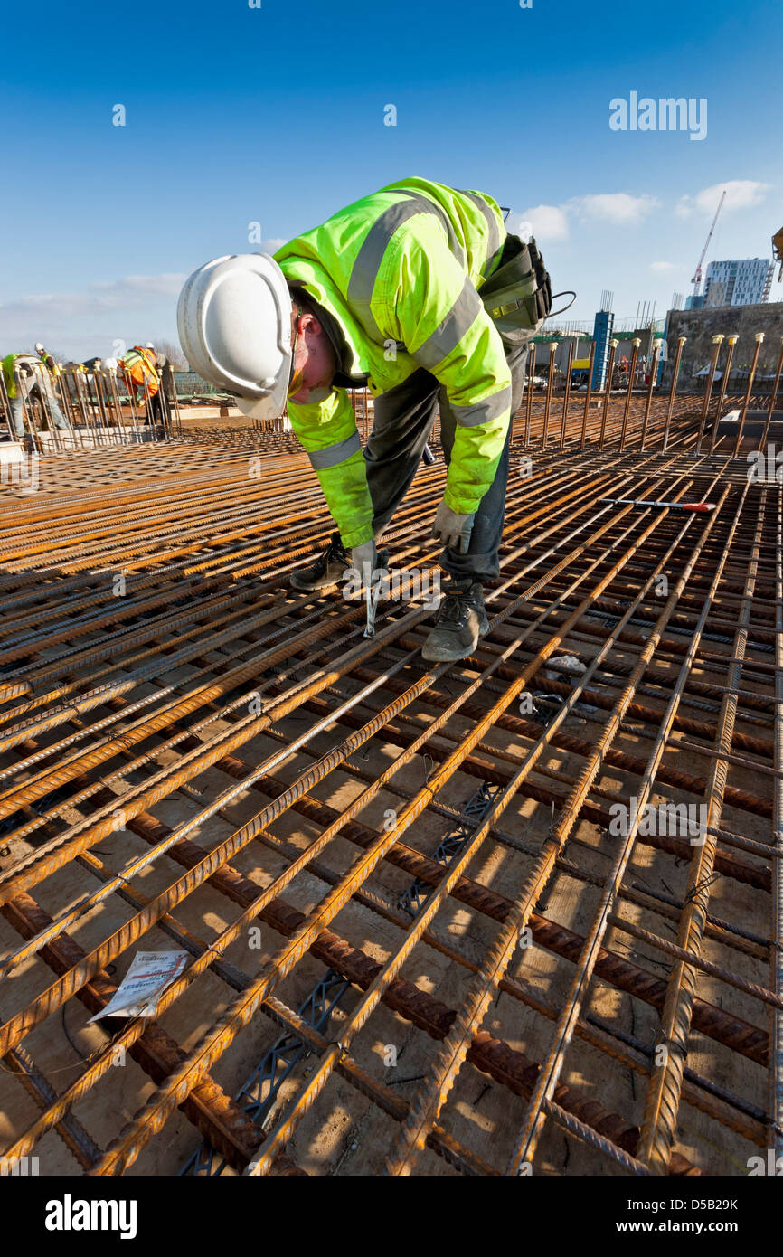 Los trabajadores en el sitio de construcción preparación de acero para hormigón armado, verter Foto de stock