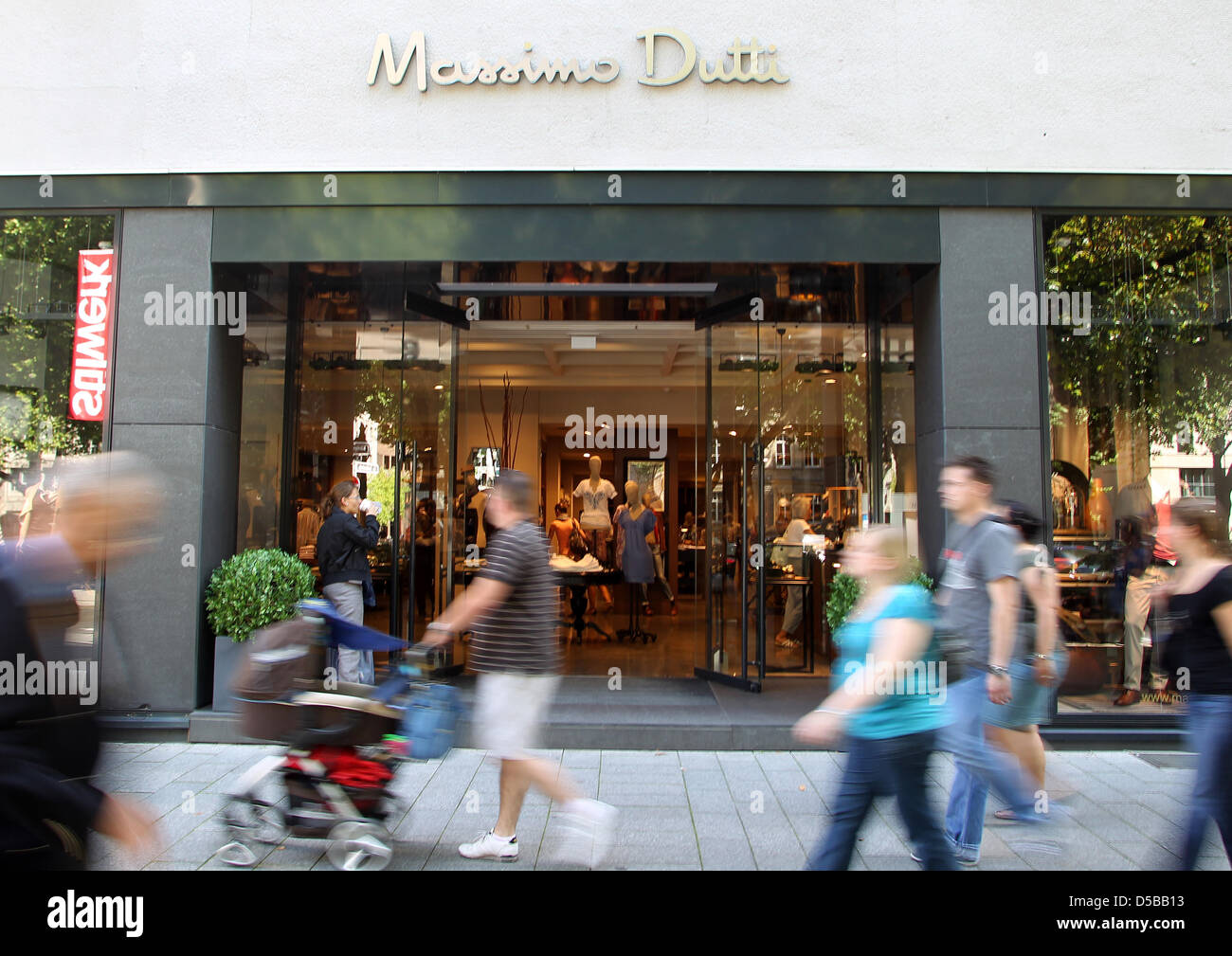 Passanten laufen am Freitag (20.08.2010) auf der Düsseldorfer Königsallee  un einer Filiale des Modegeschäftes vorbei 'Massimo Dutti'. Das Modelable  gehört zum spanischen Bekleidungsriesen Inditex, der neben den 8 Massimo  Dutti Läden noch