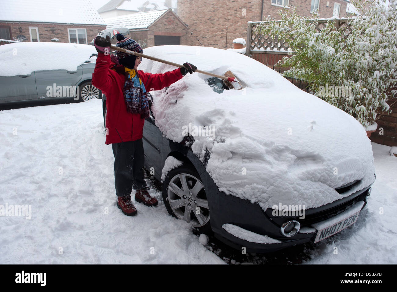 Un joven de 11 años desaparece la nieve fuera de la unidad y los padres coches fuera de su casa en Yorkshire, Reino Unido. Foto de stock