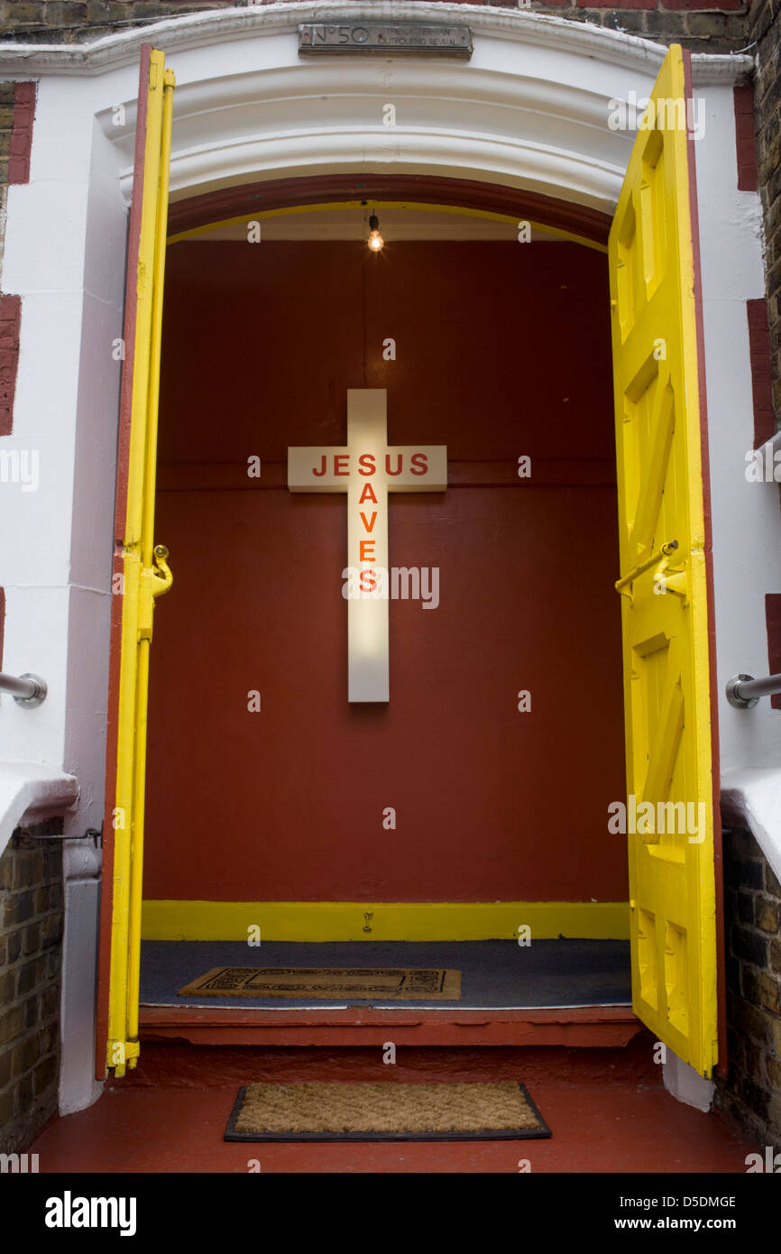Jesús salva a un cartel de neón en la entrada de una iglesia evangélica en  Peckham, al sur de Londres. Las puertas de color amarillo en la parte  superior de los pasos