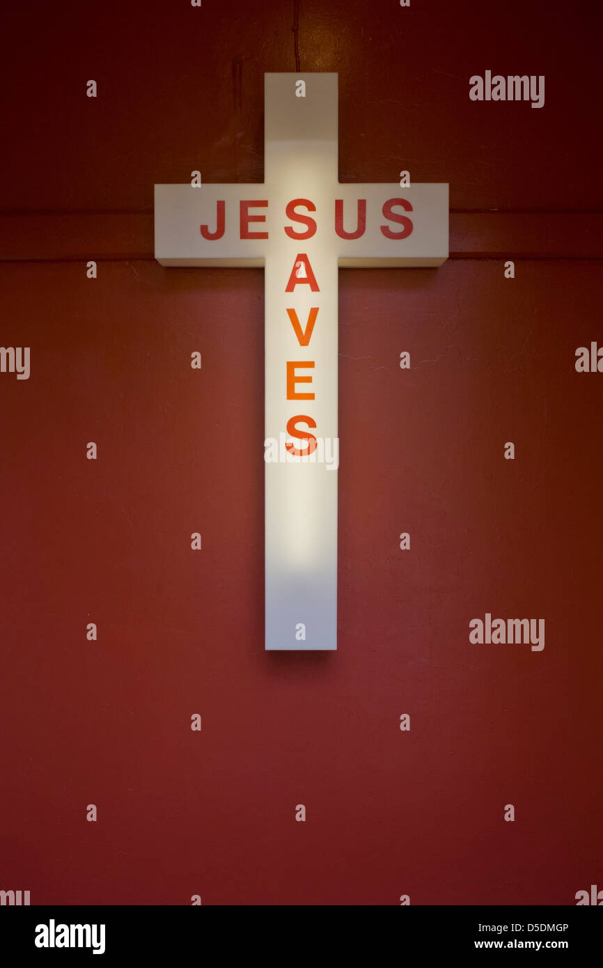 Jesús salva a un cartel de neón en la entrada de una iglesia evangélica en  Peckham, al sur de Londres. Cerca están las voces y los gritos de los  fieles, reunidos el