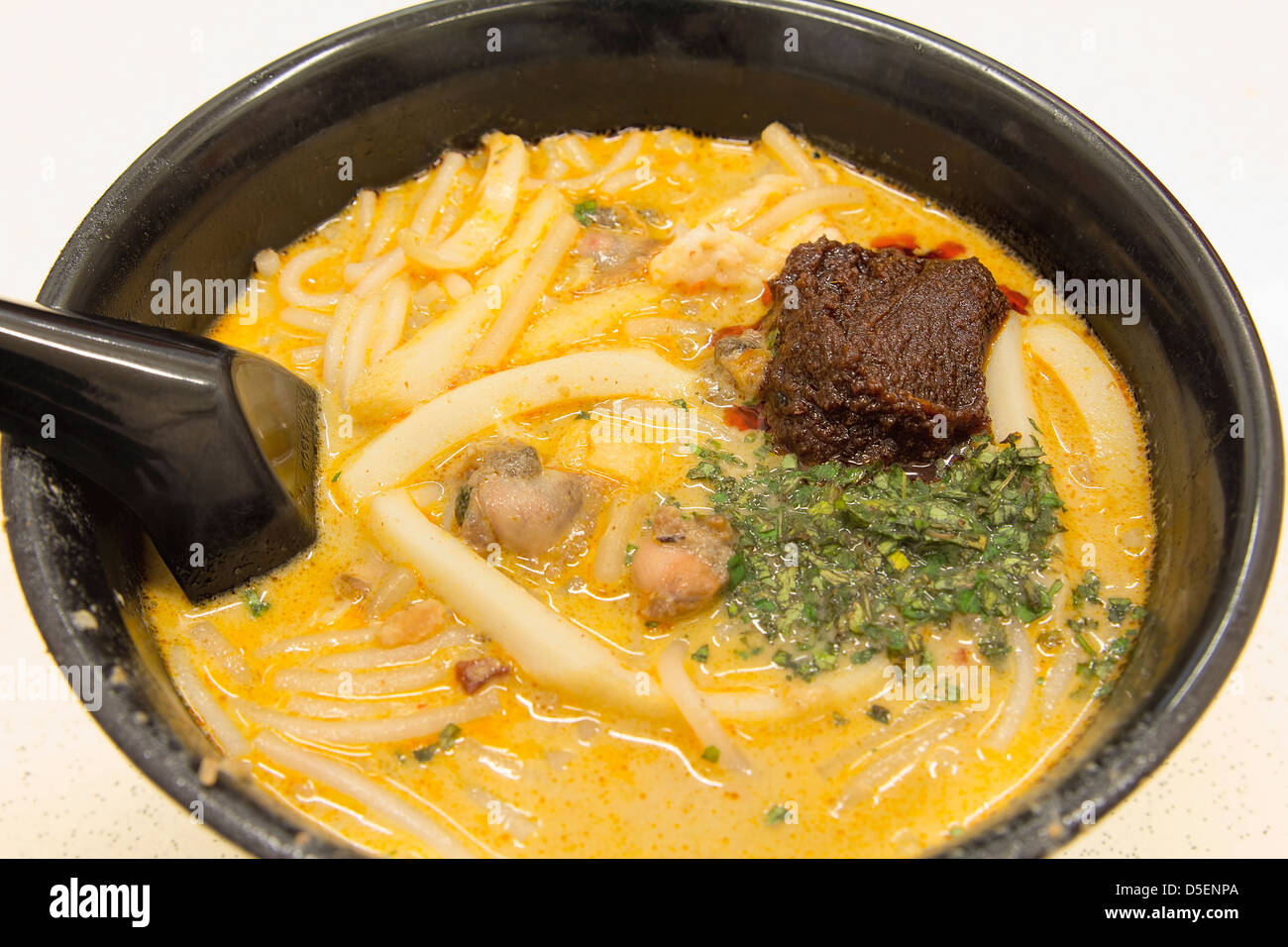 Singapur Curry Laksa Noodles con pasta de chile Sambal gambas y berberechos Fishcake Sudeste Asiático plato local Closeup Foto de stock