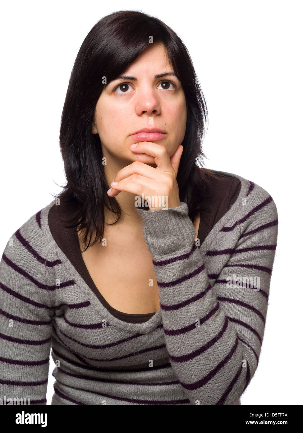 Retrato de mujer joven pensativa con la mano en el mentón aislado sobre fondo blanco. Foto de stock