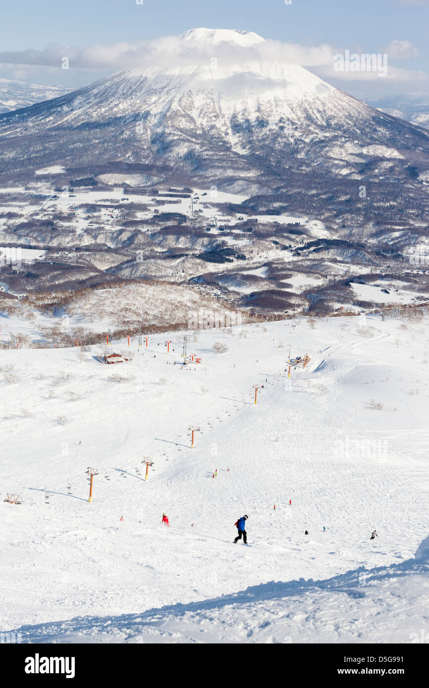 Vista panorámica de las pistas de esquí en el monte Niseko Annupuri en la estación de esquí de Niseko con Monte Yotei en el fondo Foto de stock
