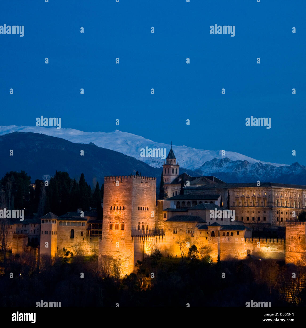 Alhambra Palace Sitio de Patrimonio Mundial de la UNESCO y el panorama de las montañas de Sierra Nevada al atardecer crepúsculo Granada Andalucía España Europa Foto de stock