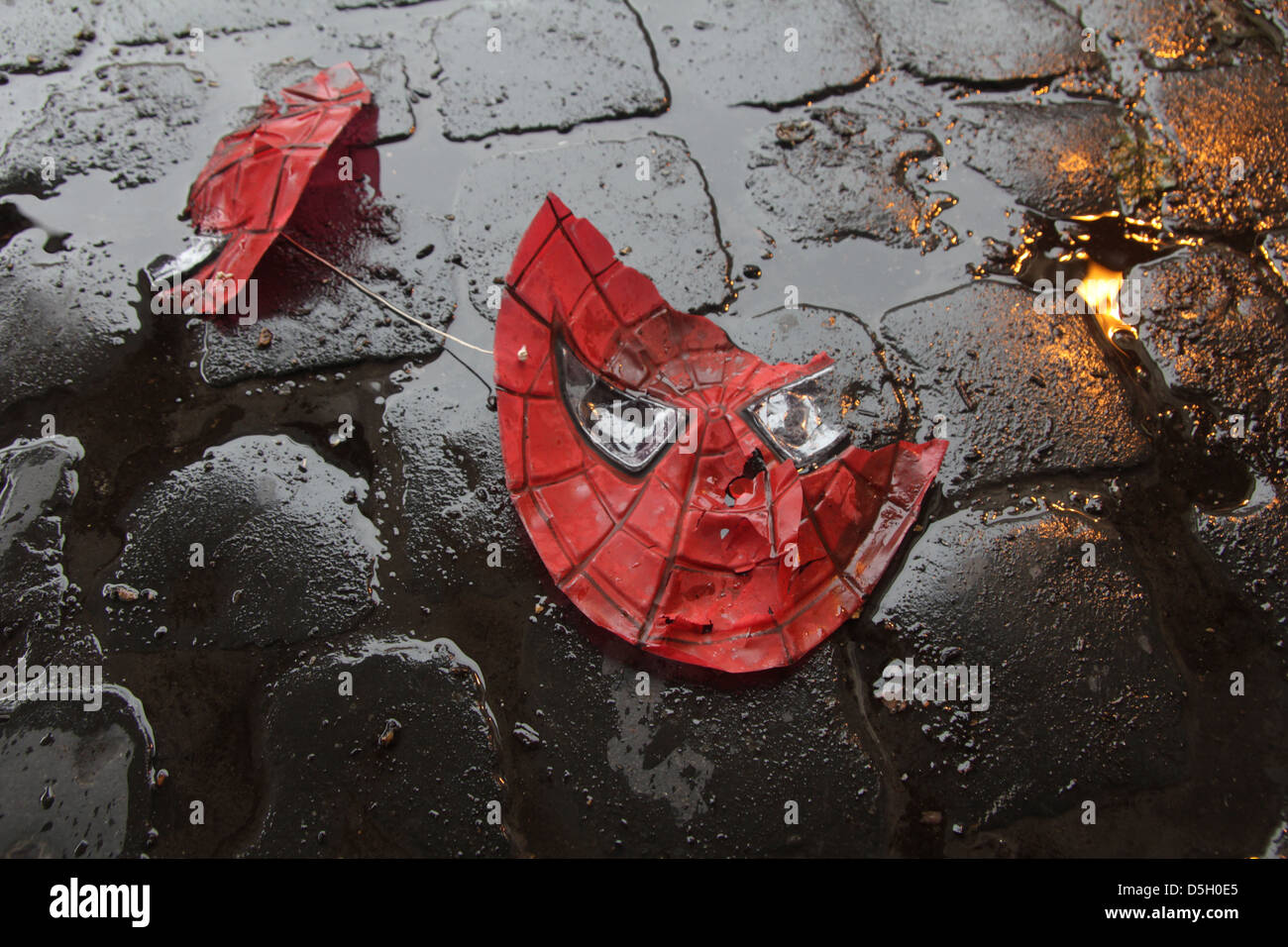 Spiderman roto plástico máscara sobre carreteras mojadas en la ciudad  Fotografía de stock - Alamy