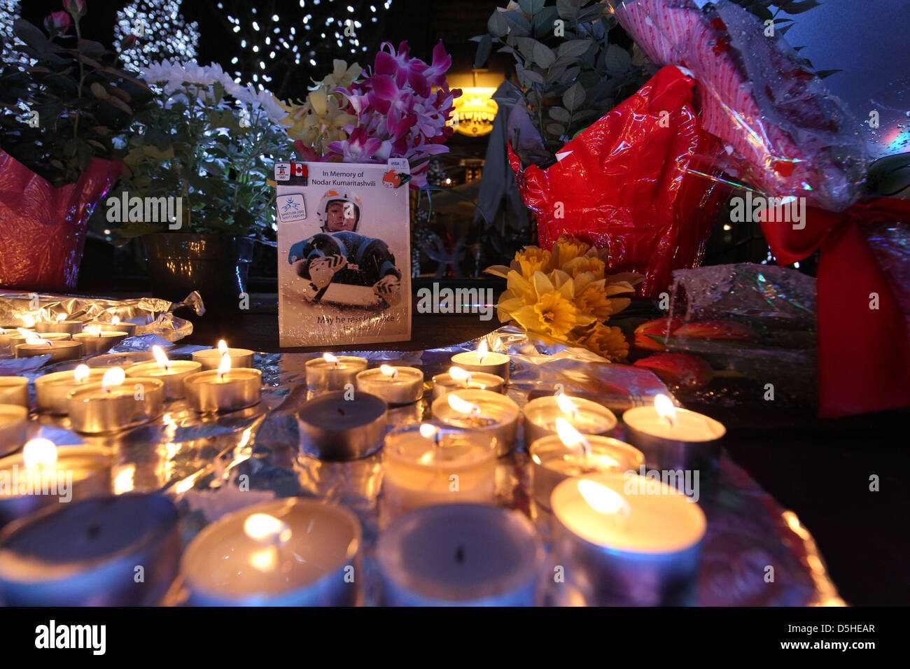 Flores y velas rodean una foto del luger georgiano Nodar Kumaritashvili en  la parte inferior de los anillos olímpicos en Whistler, Canadá, 13 de  febrero de 2010. Kumaritashvili falleció tras chocar durante