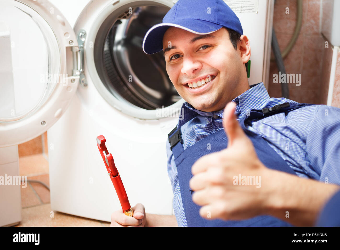 Retrato de un técnico de reparar una lavadora Foto de stock
