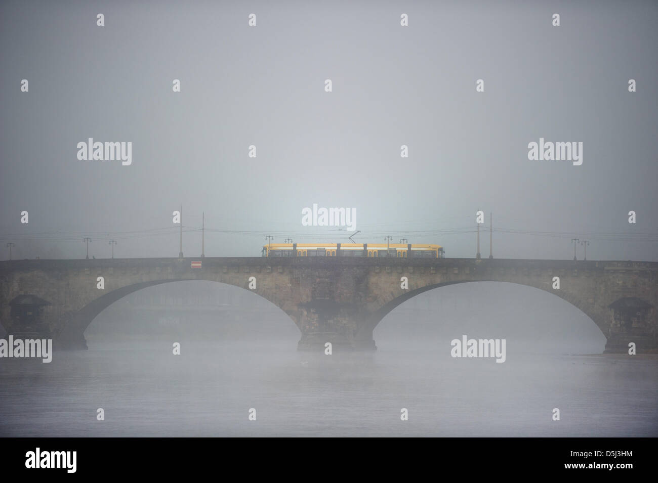 Un coche de la calle amarillo viaja a través de la niebla en el puente de agosto en Dresden, Alemania, el 13 de noviembre de 2012. Foto: Arno Burgi Foto de stock