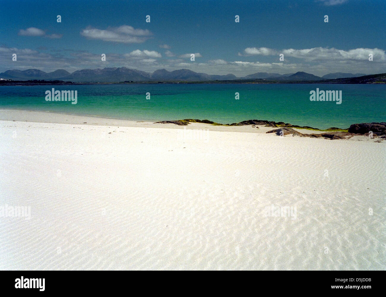 Una playa de arena de plata en la isla de Inishlacken con el Twelve Bens en el fondo, Connemara, Irlanda Foto de stock