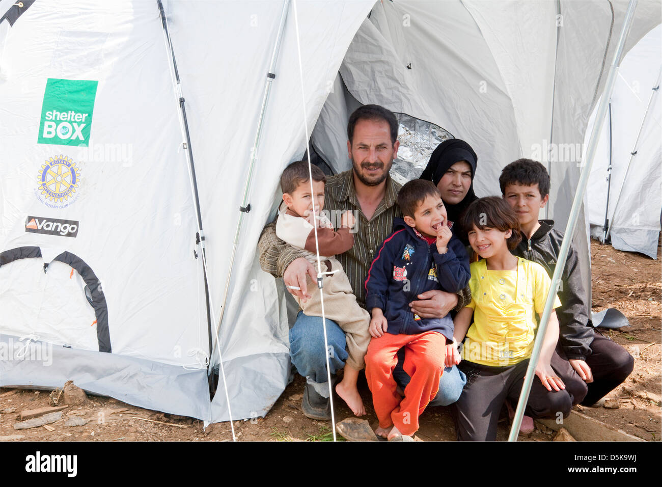 Familia de refugiados, procedentes de Homs en un improvisado campamento de refugiados en el Líbano Minie, NE con su nueva tienda ShelterBox Foto de stock