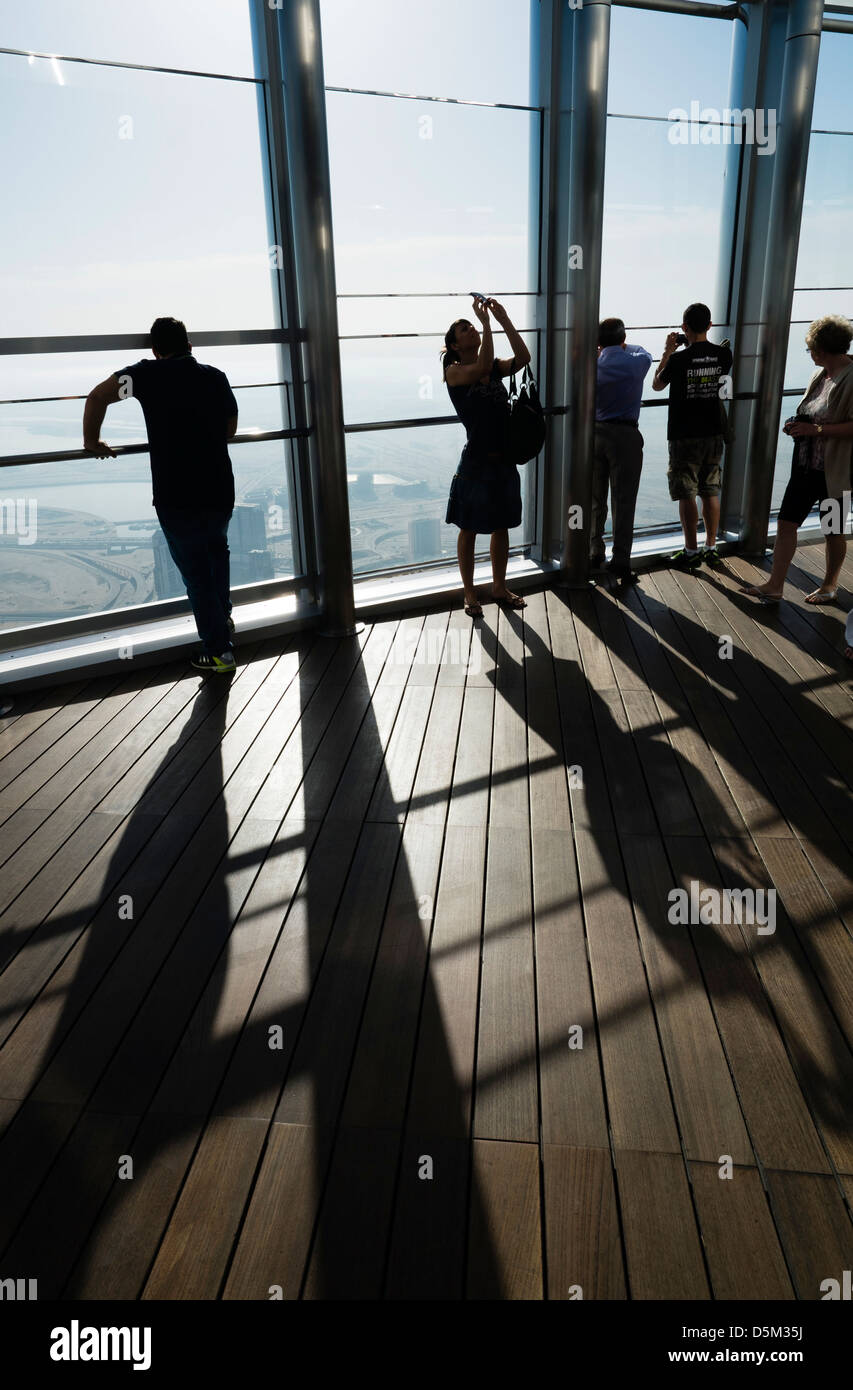 Los turistas mirando a lo largo de Dubai en la parte superior de la plataforma de observación en el Burj Khalifa la estructura más alta del mundo en Dubai Uni Foto de stock