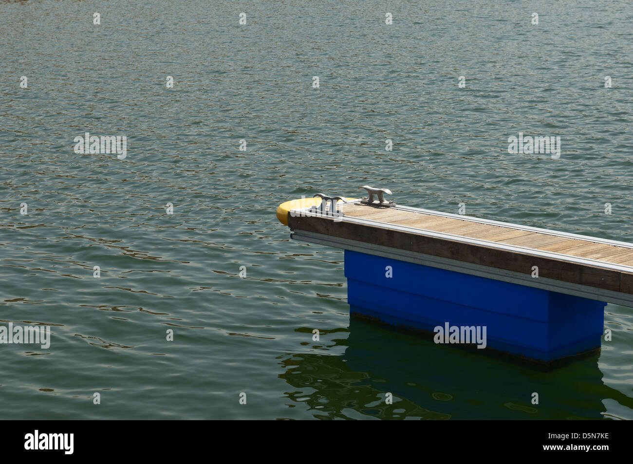 Detalle de un dique flotante de madera con bitas de amarre Foto de stock