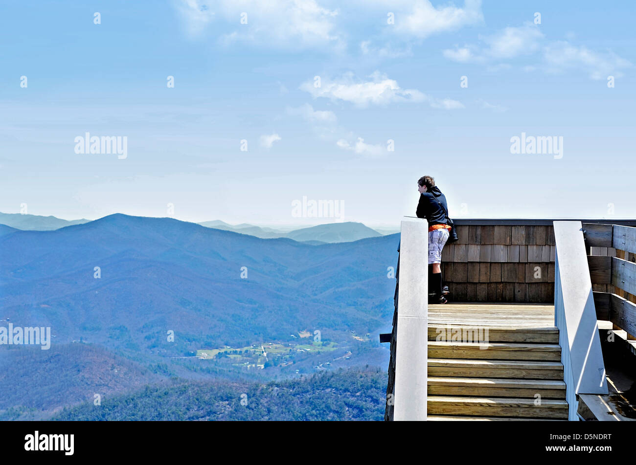 Un muchacho en una torre de observación con vistas a las montañas en Bald en Georgia. Foto de stock