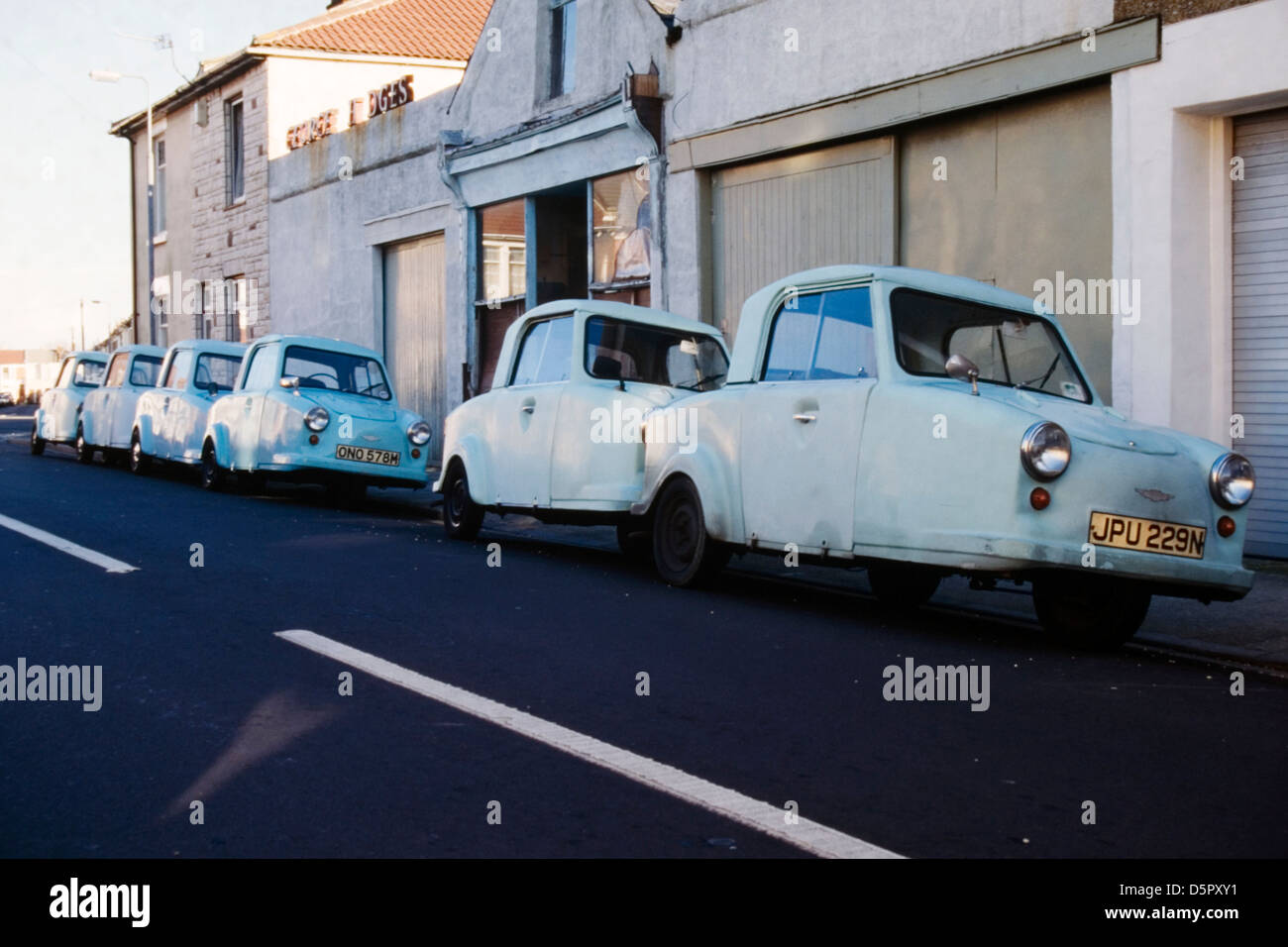 Vista inusual de una línea de tres ruedas thundersley ca coches no válido en una calle urbana, cerca del garaje especialista Foto de stock