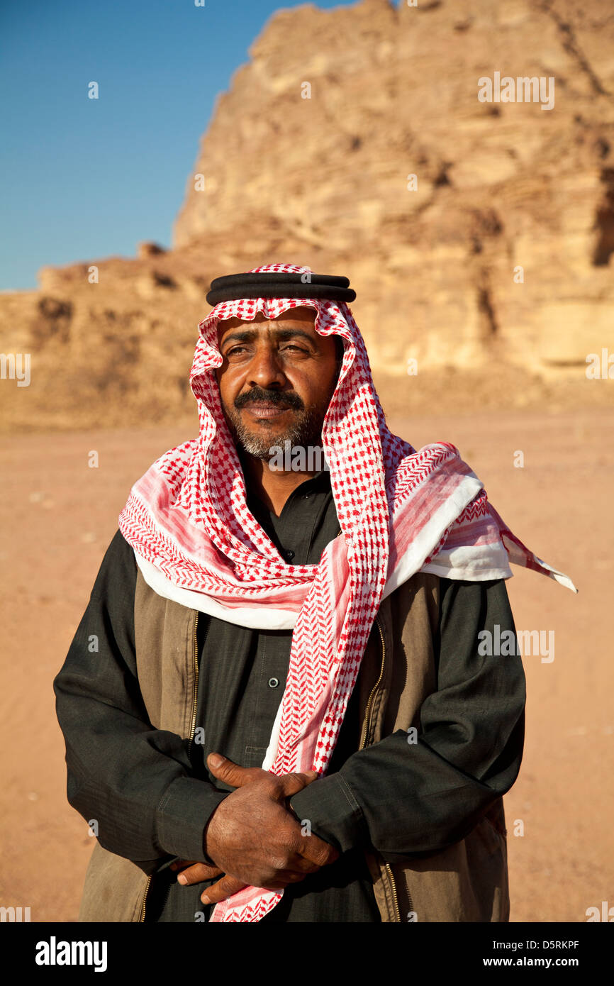 Un beduino hombre vestido con el rojo y blanco a cuadros keffiyeh bufanda en Wadi Rum, Jordania Foto de stock