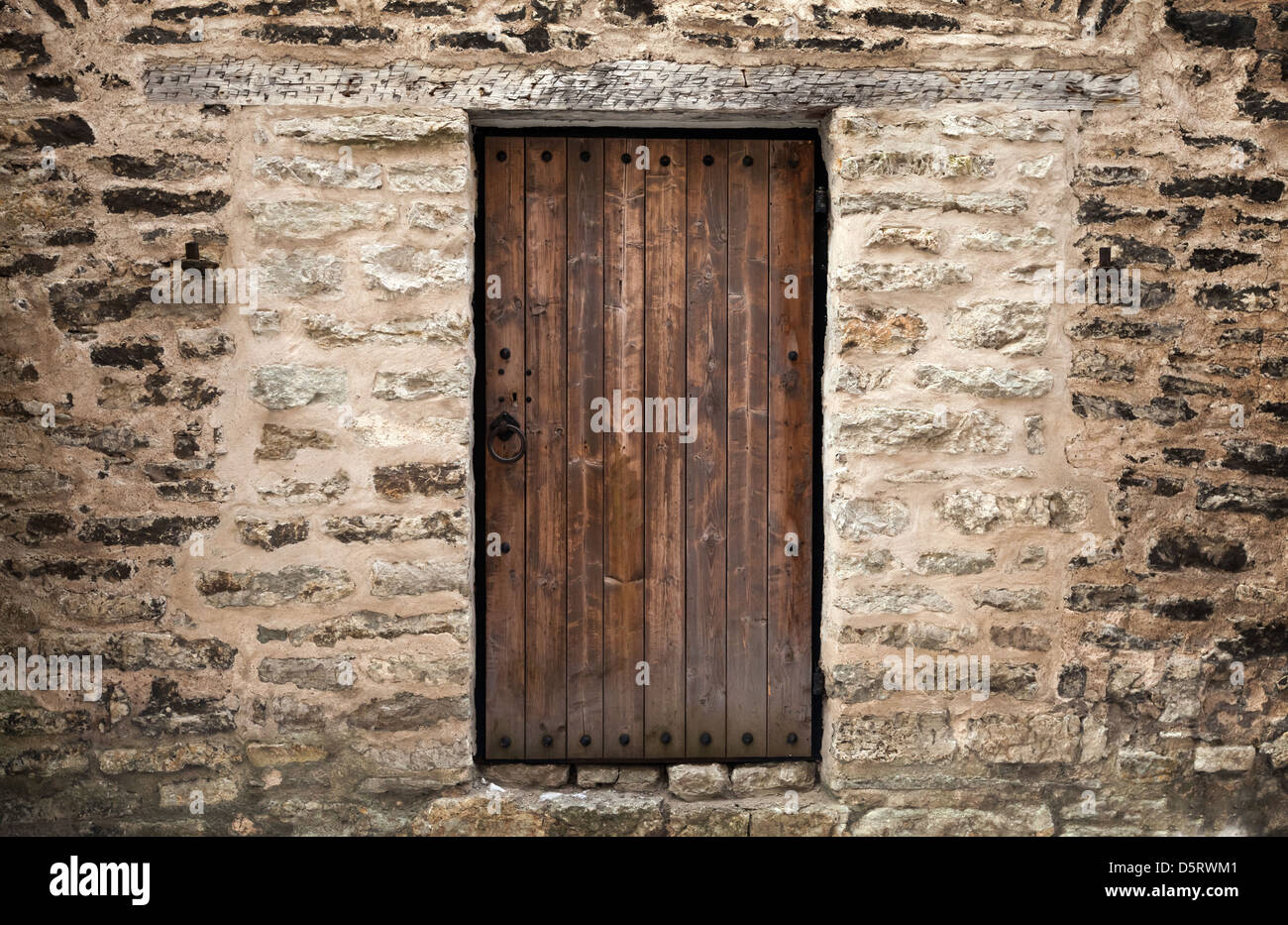 La antigua puerta de madera en la pared de castillo de piedra. Tallinn, Estonia Foto de stock