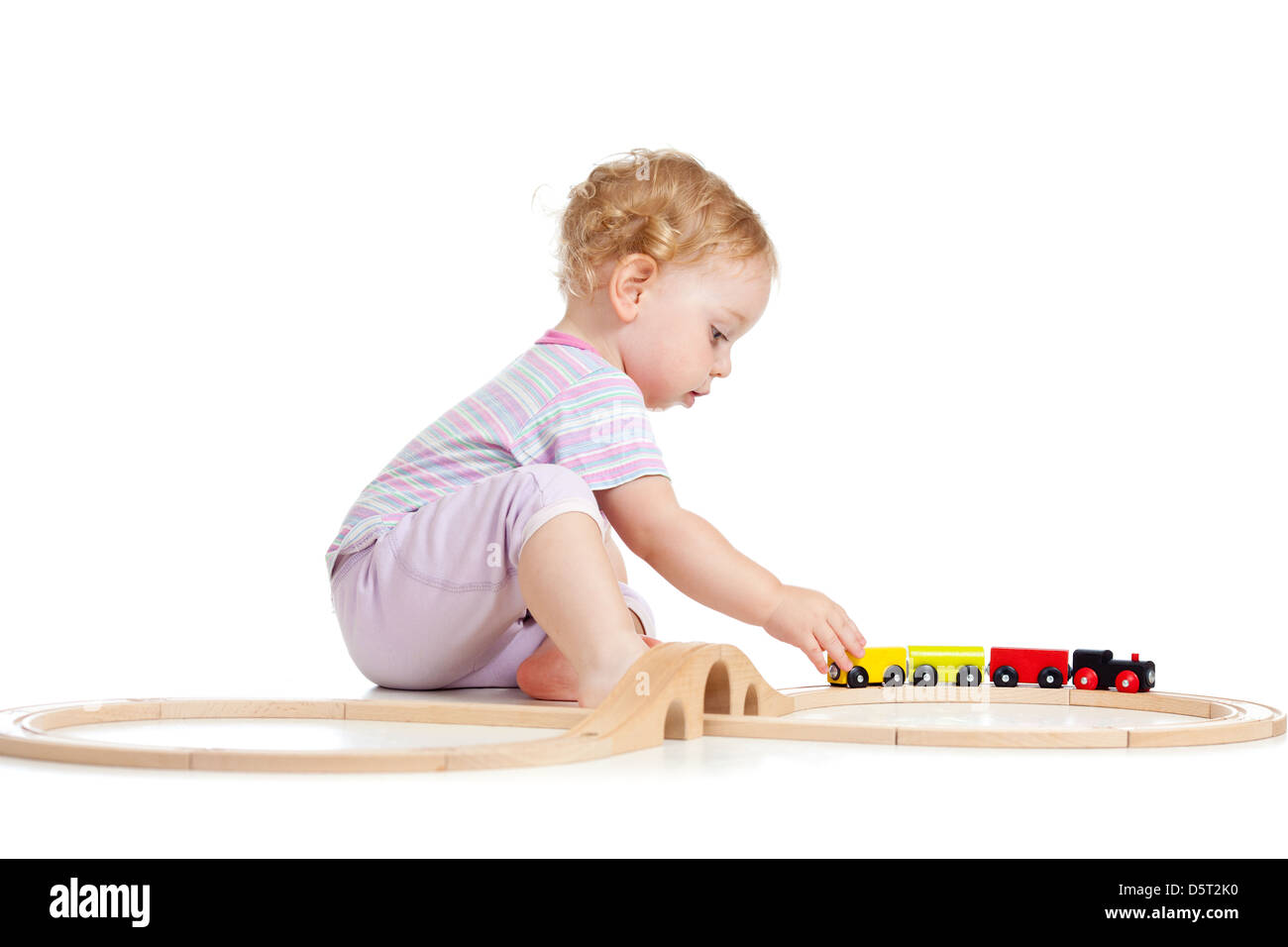 Lindo niño está jugando con tren de madera aislado en blanco Foto de stock