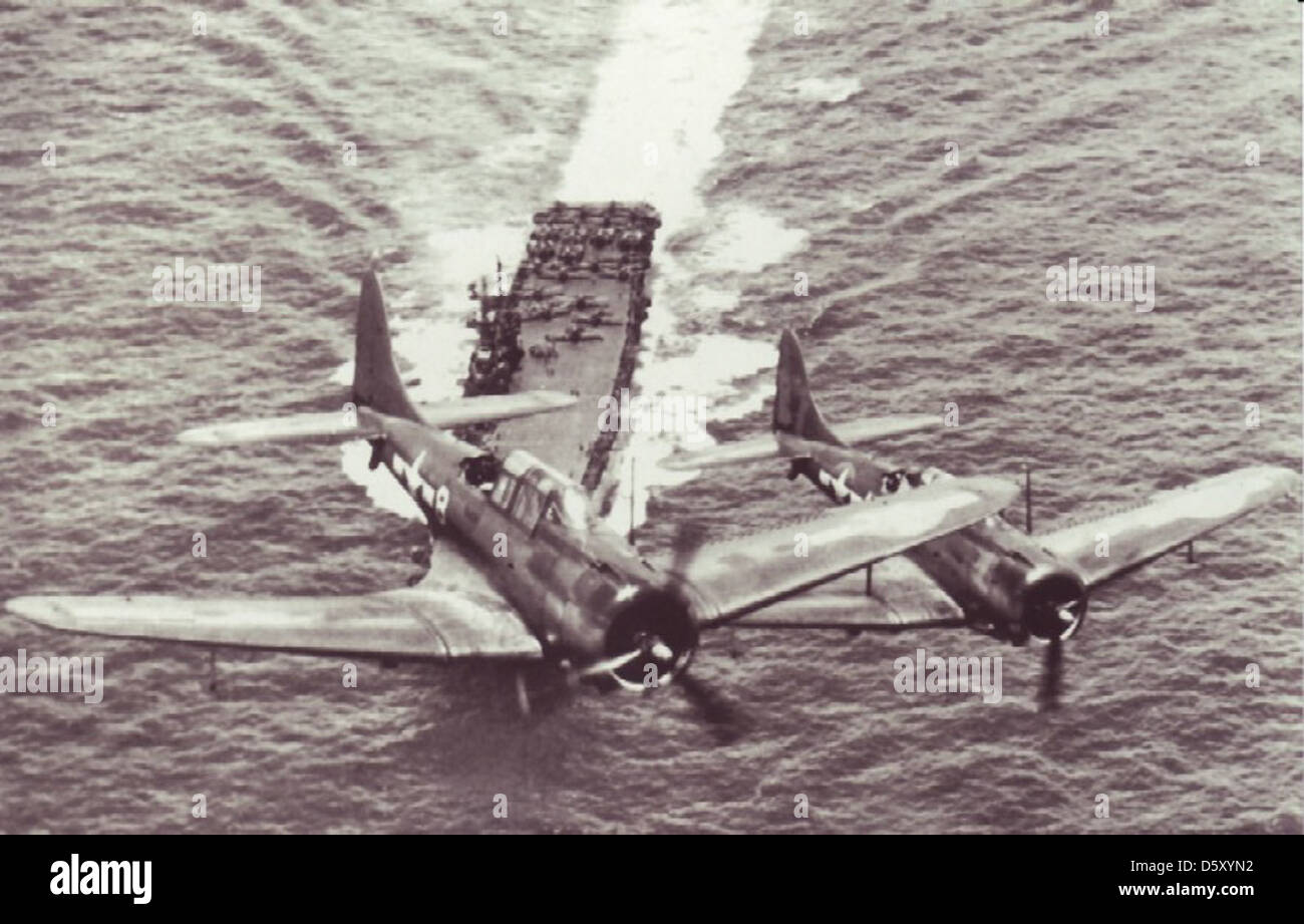 Dos Grupo Aéreo 10 Douglas SBD 'Dauntlesses' sobrevolar el USS ENTERPRISE (CV-6), probablemente en junio de 1944. Foto de stock