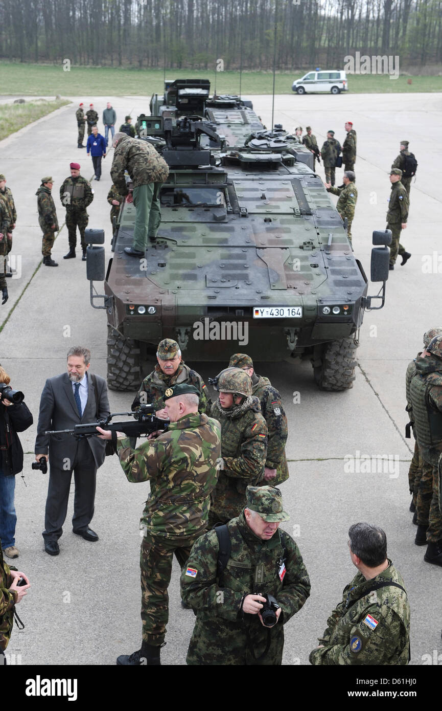 Los representantes de la OSCE y los soldados ver un GTK tipo boxer vehículos blindados de combate durante una presentación de los sistemas de armas por la Fuerza de Defensa Federal alemán en la zona de entrenamiento militar en Putlos, Alemania, el 25 de abril de 2012. Los representantes de los Estados miembros de la Organización para la Seguridad y Cooperación en Europa (OSCE) de la ONU visitó la presentación como parte de la serie de eventos Foto de stock