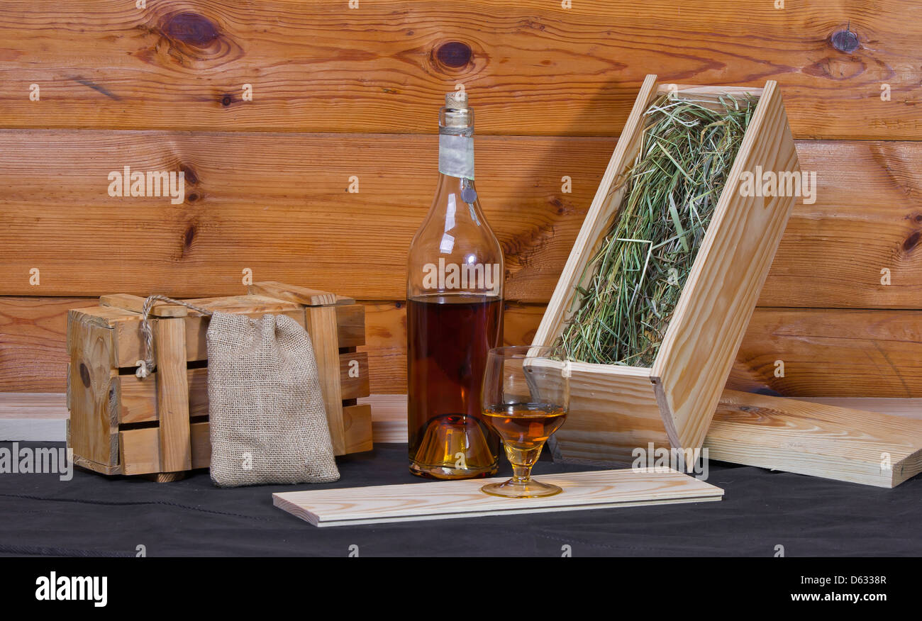 Bodegón con una botella de brandy, cajas de madera y vidrio Foto de stock