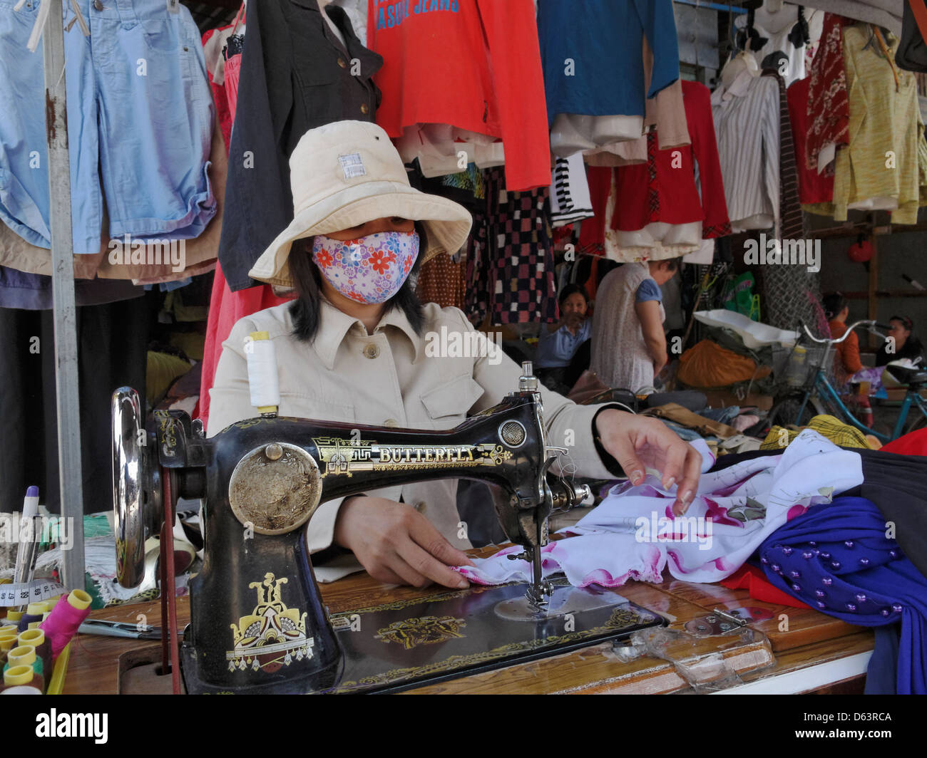 Una costurera con máquina de coser una mariposa mercado en Nha Trang, Vietnam. Foto de stock
