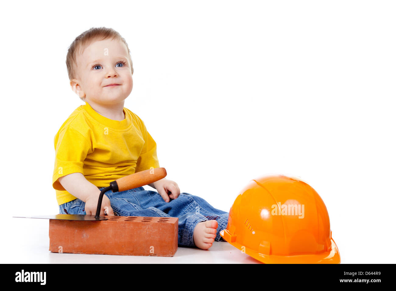 Niño sonriente con sombrero duro y herramientas de construcción Foto de stock