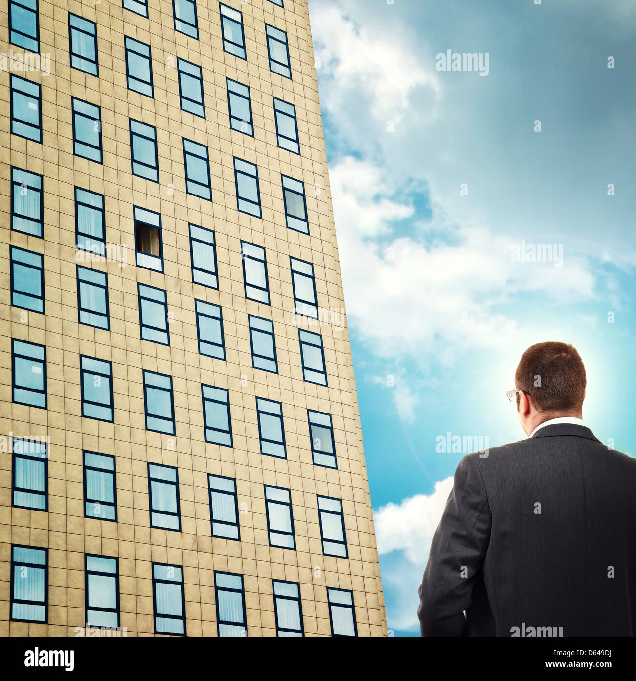 Empresario en frente del edificio de la empresa mirando al abrir la ventana de la oficina. Oportunidad de negocio. Foto de stock