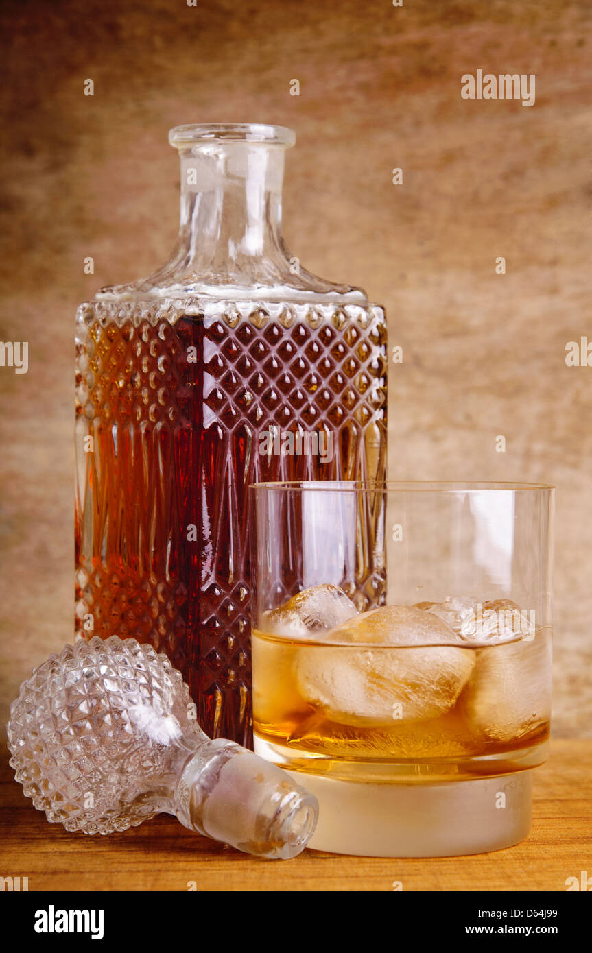 Vidrio y botella de whisky sobre un fondo de madera Foto de stock