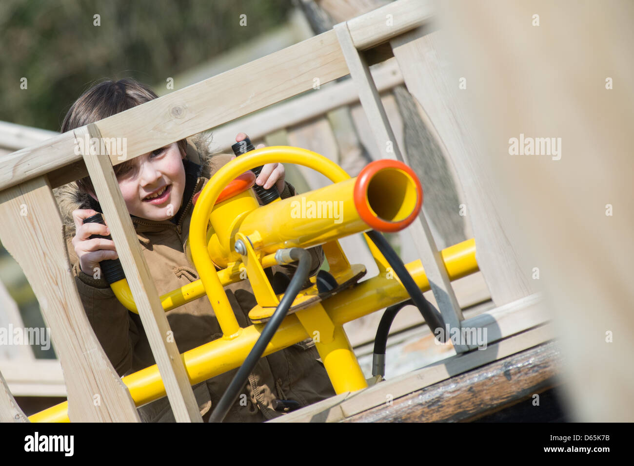 Un niño pequeño jugando con un cañón neumático en el Crealy Adventure Park atracción turística en Cornualles, Reino Unido Foto de stock