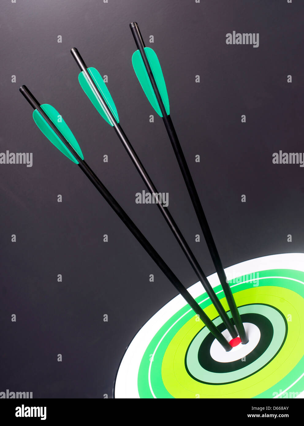 Tres flechas verde y negro Hit mesas multicolores Bullseye Target Center Foto de stock