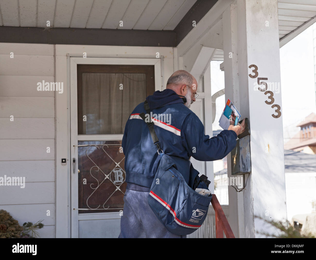 Un transportista del Servicio Postal de Estados Unidos entrega correo a residencias en Milwaukee, Wisconsin. Foto de stock
