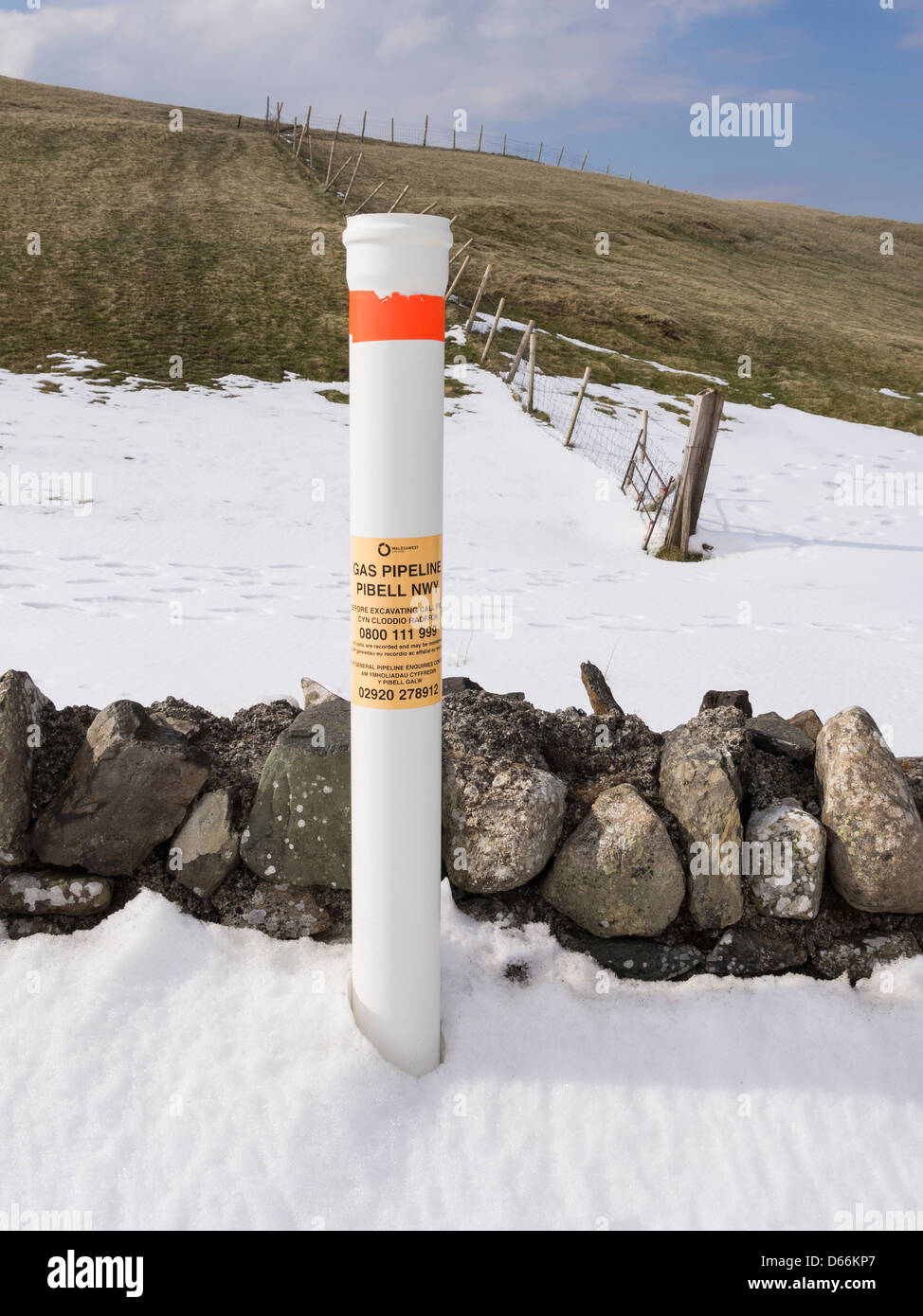 Marcador de posición posterior marcado gasoducto subterráneo en la nieve en la campiña de Snowdonia cerca de Conwy, North Wales, REINO UNIDO, Gran Bretaña Foto de stock